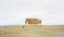 A man climbing up on the billboards. © Zhang Kechun/MoST Artists